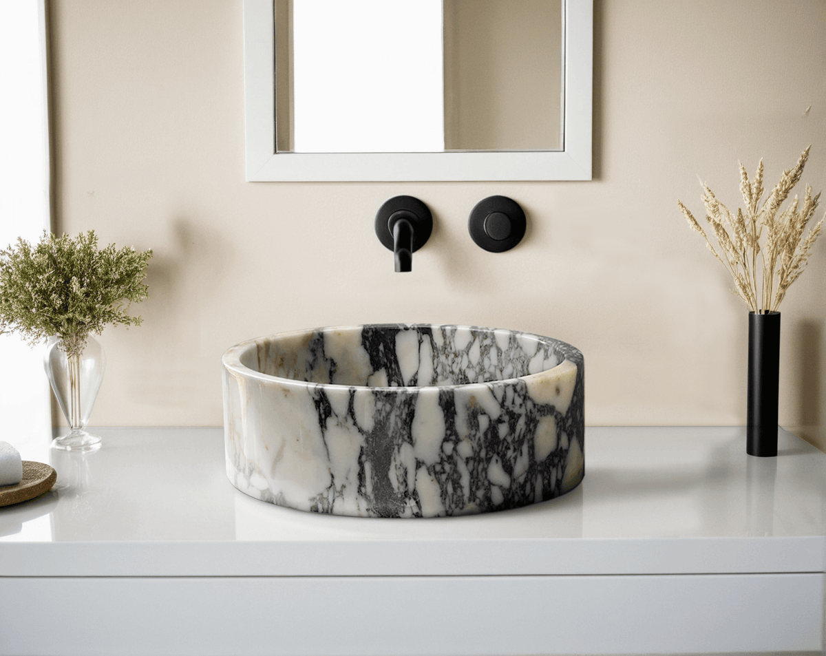 Dokimeion Calacatta marble vessel sink with black wall faucet